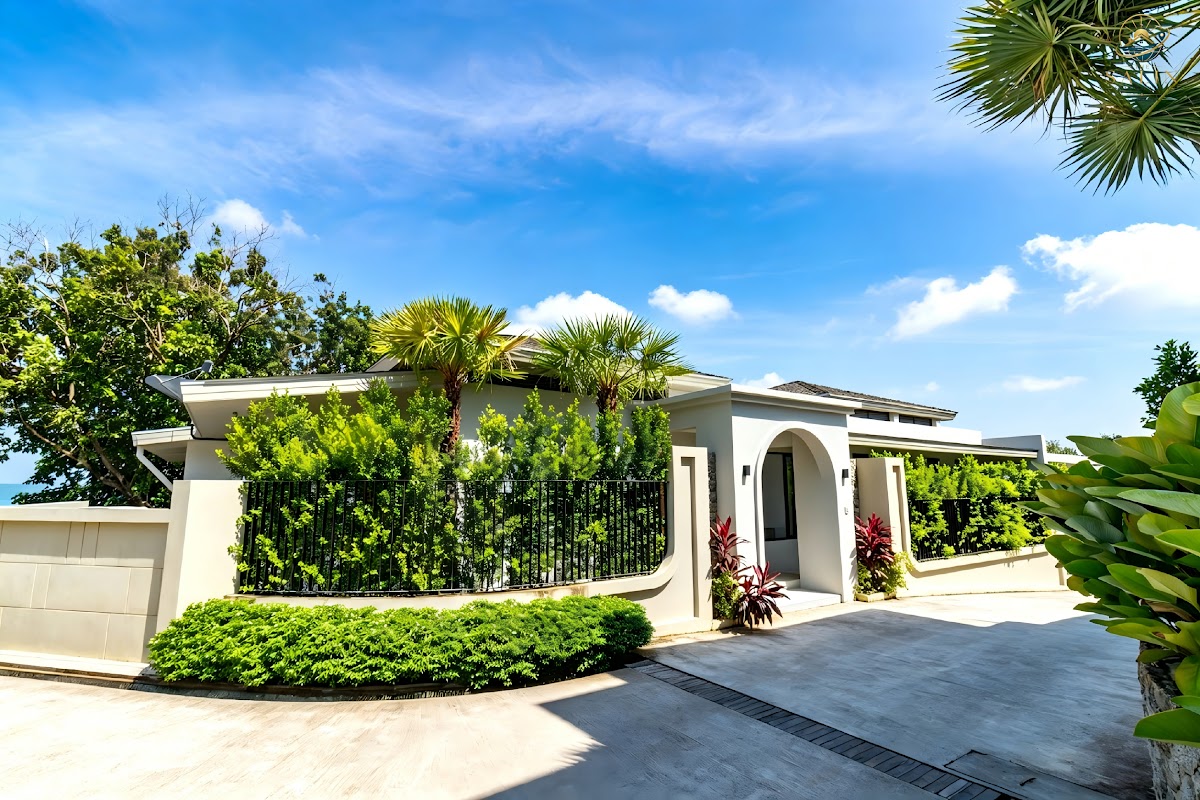 Landscaped villa entrance with tropical planting and timber door