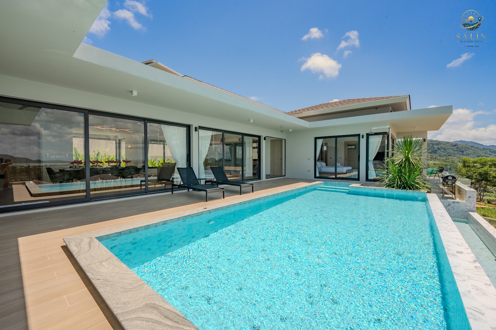 Long private swimming pool running along the villa's glass facade