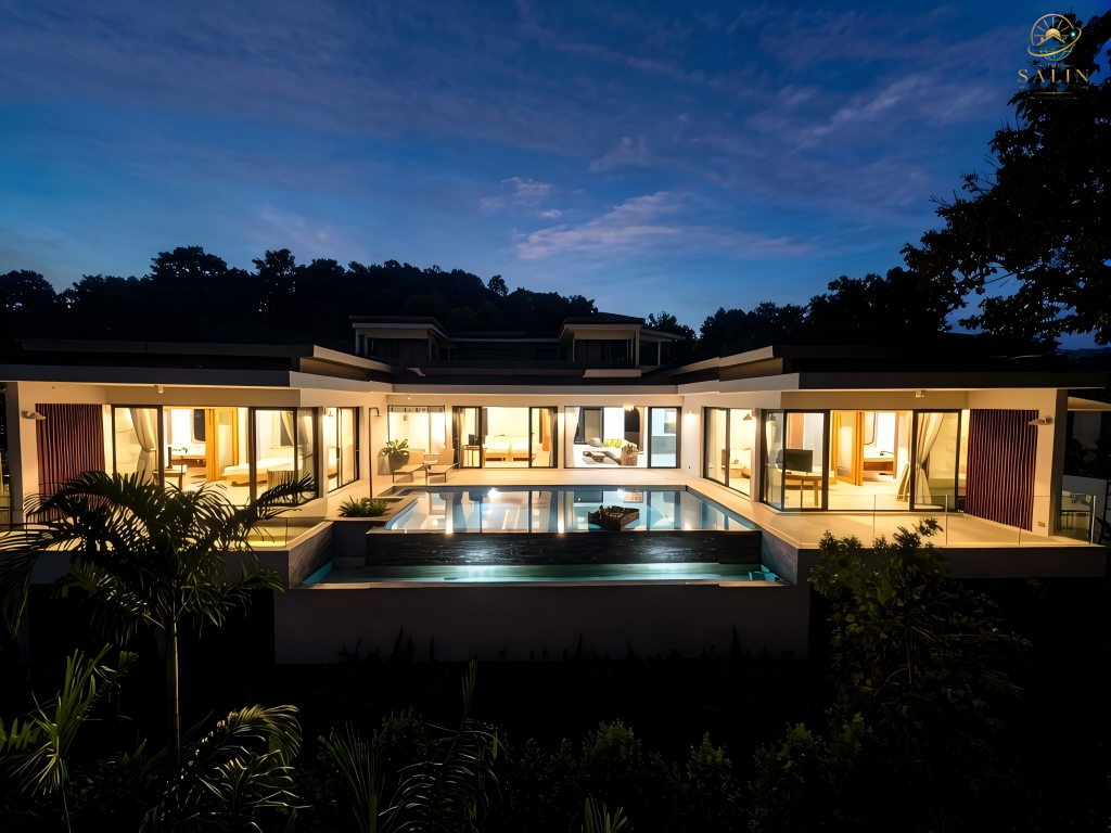 Illuminated sea-view villa and pool terrace at twilight