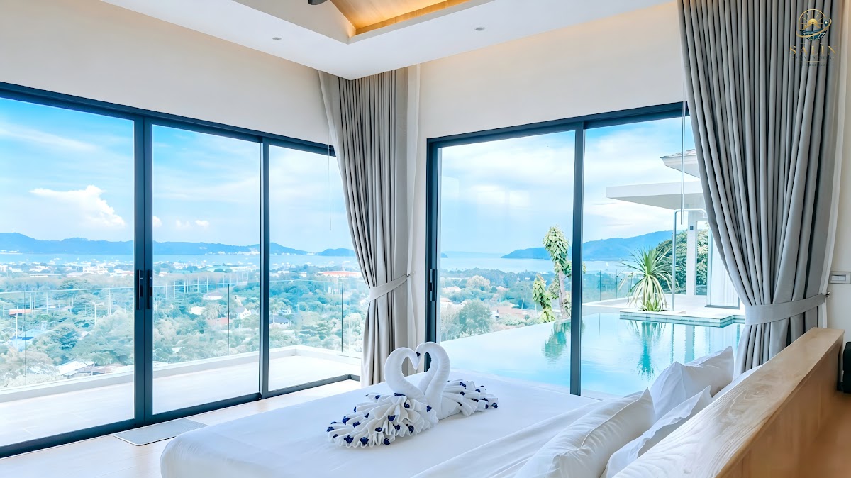 Ocean view bedroom with floor-to-ceiling windows and premium bedding